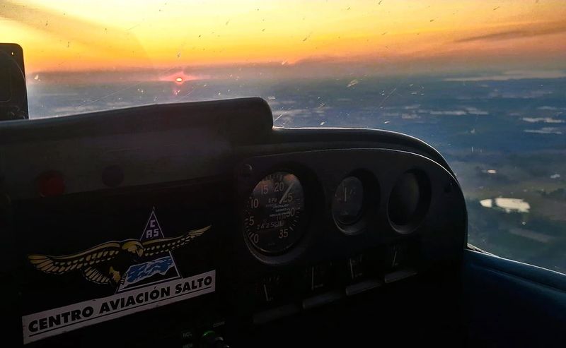 Cabina de una avioneta de instrucción al atardecer sobre Salto